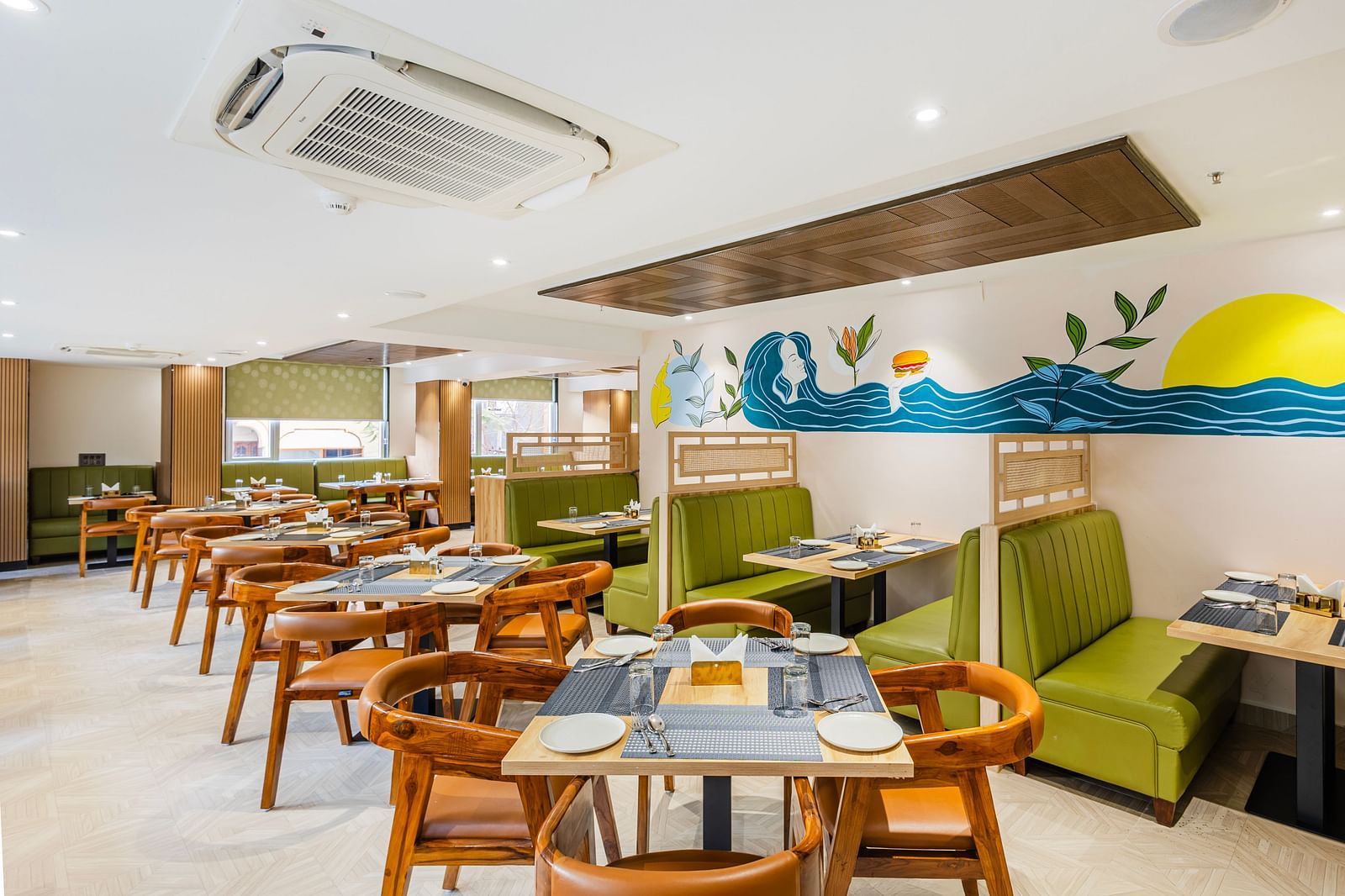 Lemonridge Hotels, KPHB | Dining area with tables and chairs, showcasing the artistic wall decor and ceiling design.